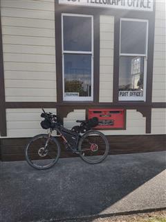 Photo of Tour Aotearoa 2024: rider Stephane Perron, Matakohe post and telegraph office